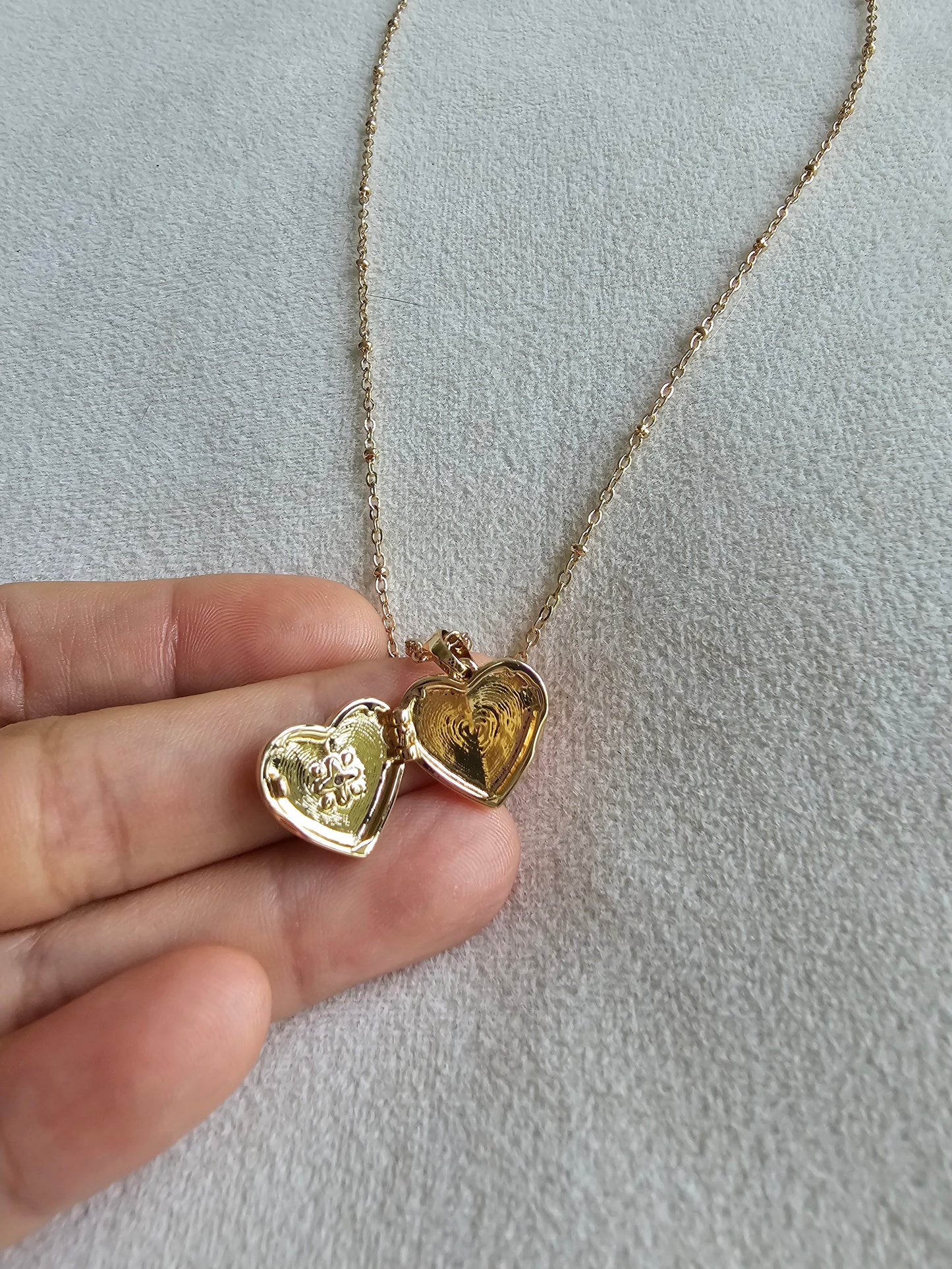Gold heart-shaped pendant necklace opened