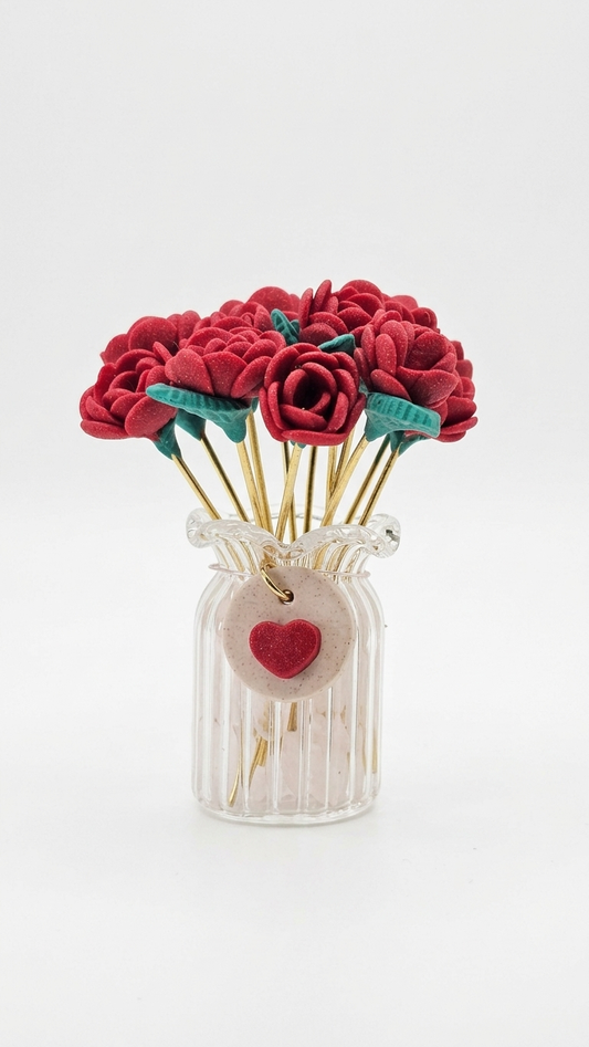 Red felt flowers in a glass jar with a heart tag on a white background
