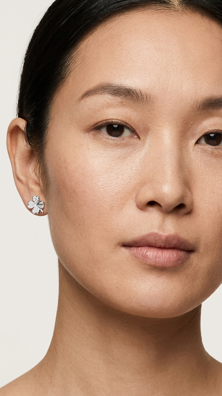Close-up of a woman wearing a floral earring against a plain background