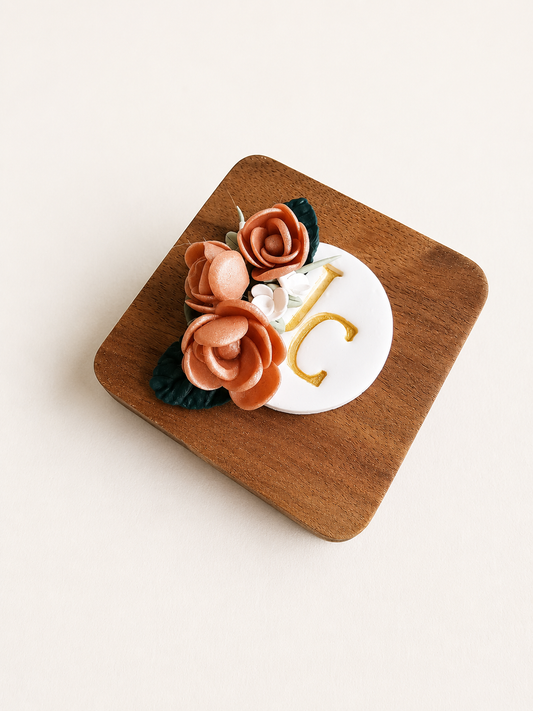 Wooden coaster with floral design and letter 'C' on a white background