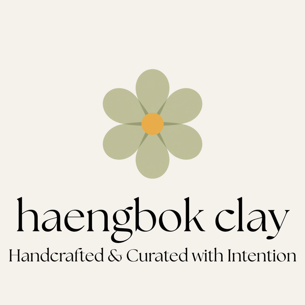 Logo of haengbok clay with a flower design on a beige background