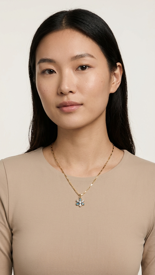 Woman wearing a necklace with a pendant on a plain background