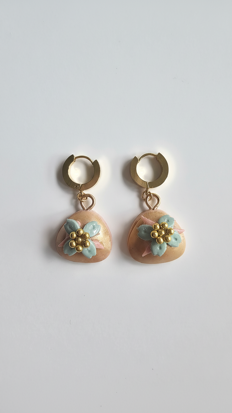 Pair of earrings with floral designs on a light gray background