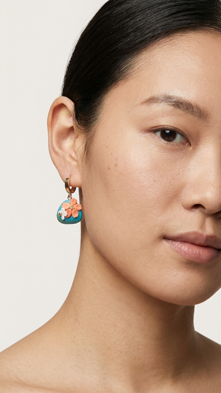 Close-up of a woman wearing a floral earring against a neutral background