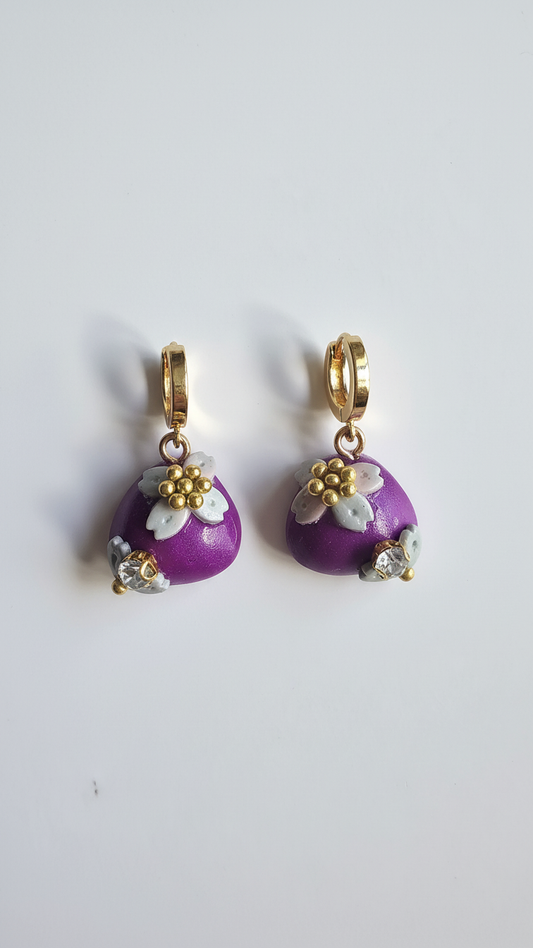 Purple earrings with floral designs on a white background