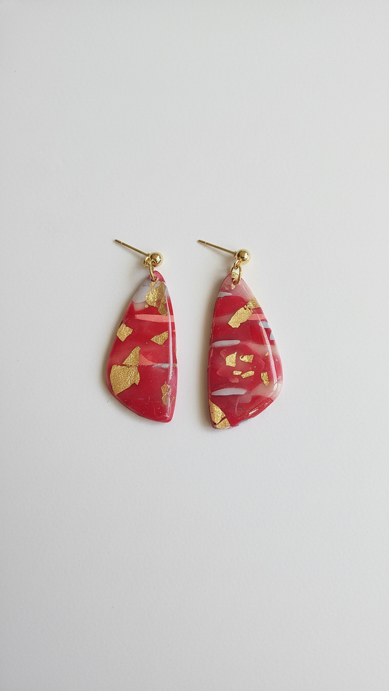 Red and gold teardrop-shaped earrings on a white background