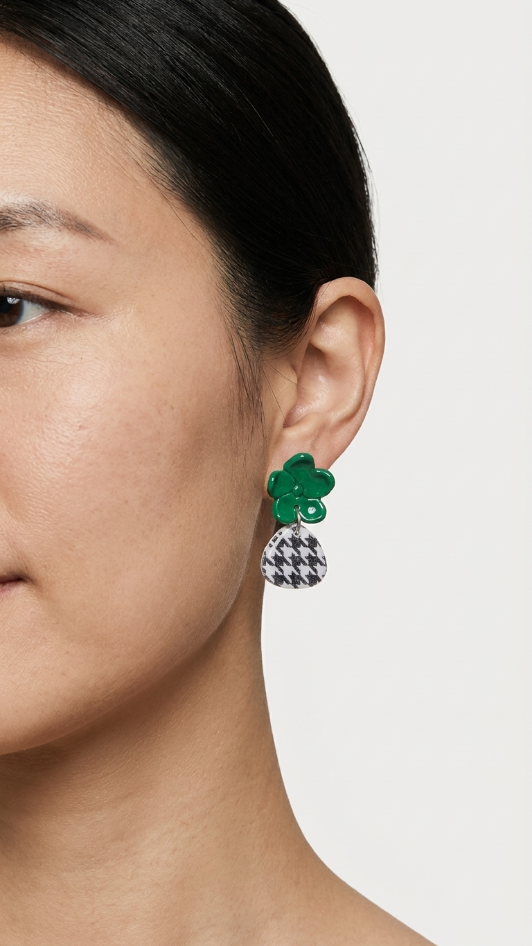Close-up of a person wearing green floral earrings with a white background