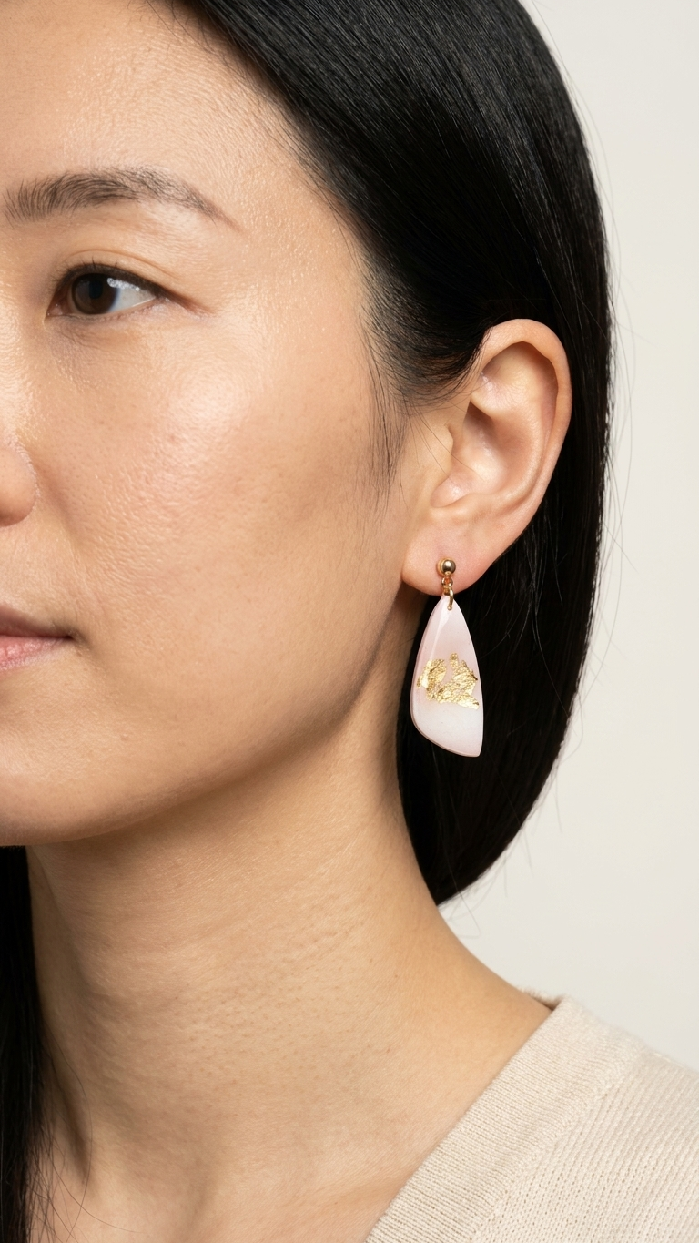 Close-up of a woman wearing a pair of earrings with a neutral background