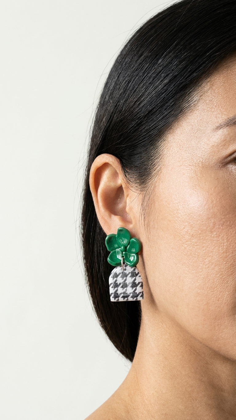 Close-up of a person wearing green floral earrings with a neutral background