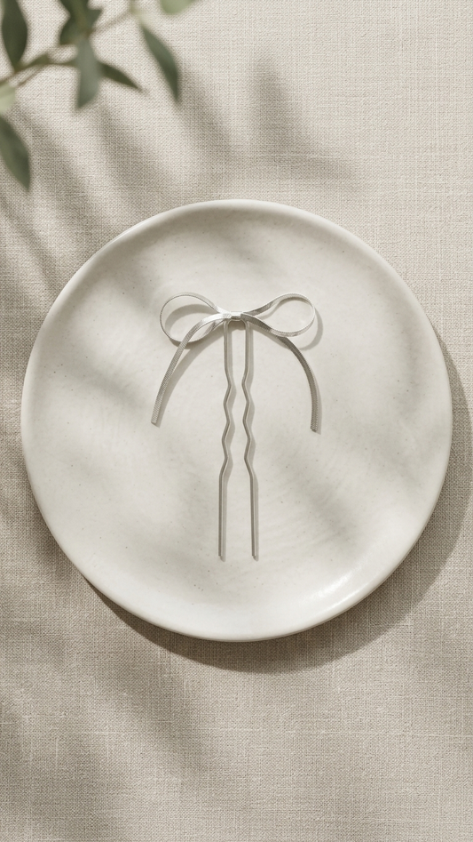 White ceramic plate with a decorative bow design on a beige fabric background