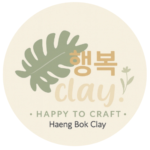 Haeng Bok Clay logo featuring a soft cream circular background, a sage green leaf illustration, Korean text “행복,” and the words “clay!” and “Happy to Craft” in warm neutral tones.