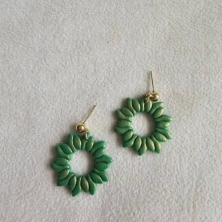 Forest green polymer clay petal wreath earrings with gold-plated stainless steel posts, photographed on a neutral fabric background