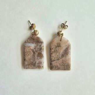 Handcrafted polymer clay arch-shaped earrings in beige marbled tones with gold flecks and gold-plated stainless steel posts on a neutral background