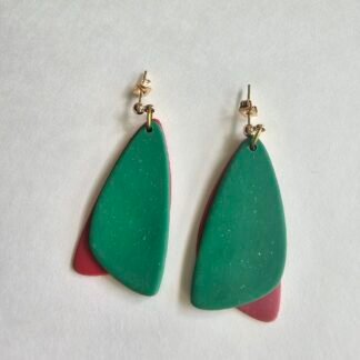 Handcrafted polymer clay layered drop earrings in deep green with terracotta accents on a neutral background