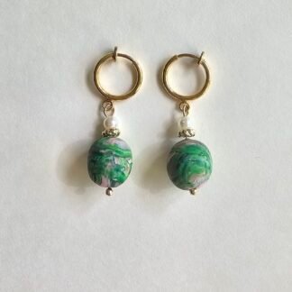 Handcrafted polymer clay marbled green oval drop earrings with pearl accent on gold hoop earrings, displayed on a neutral background