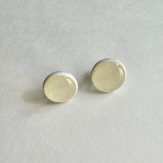Handcrafted polymer clay round stud earrings in soft pearlescent ivory on a neutral background