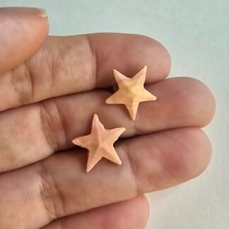 Handcrafted polymer clay blush star stud earrings with a soft matte finish on a neutral background