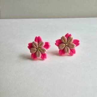 Handcrafted polymer clay pink floral stud earrings with blush petals and gold centre on a neutral background