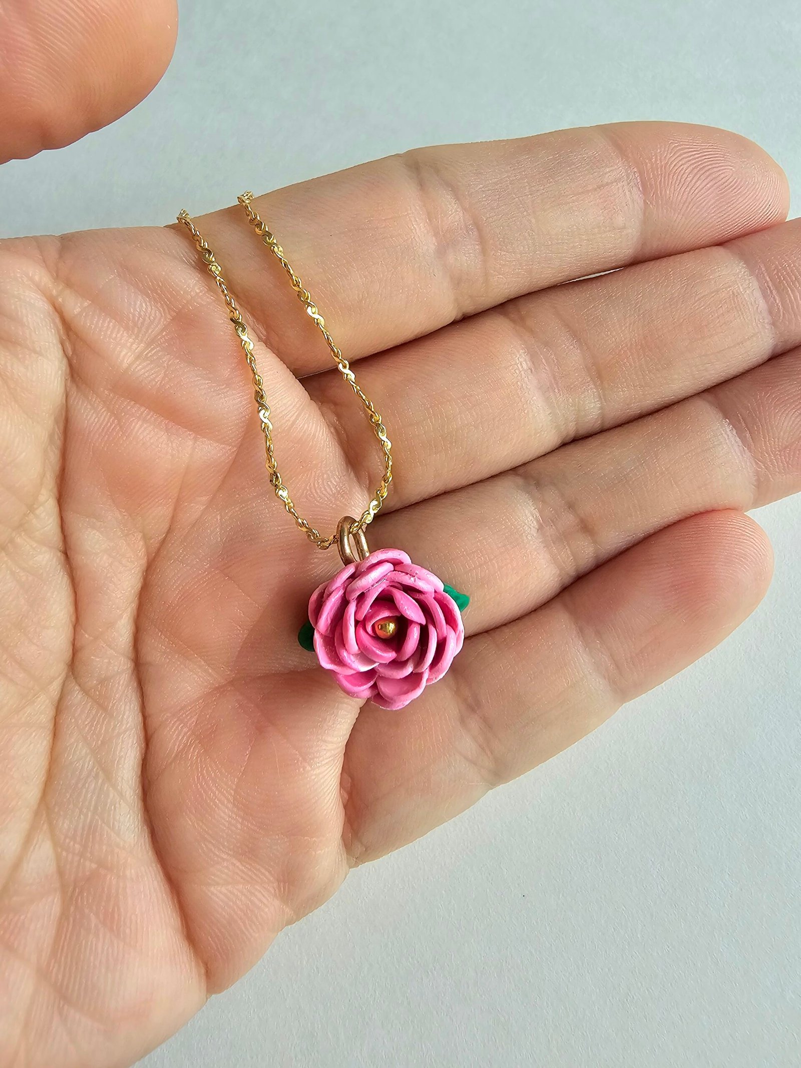 Gold plated 925 silver necklace with a handmade pink polymer clay rose charm and subtle green leaf detail