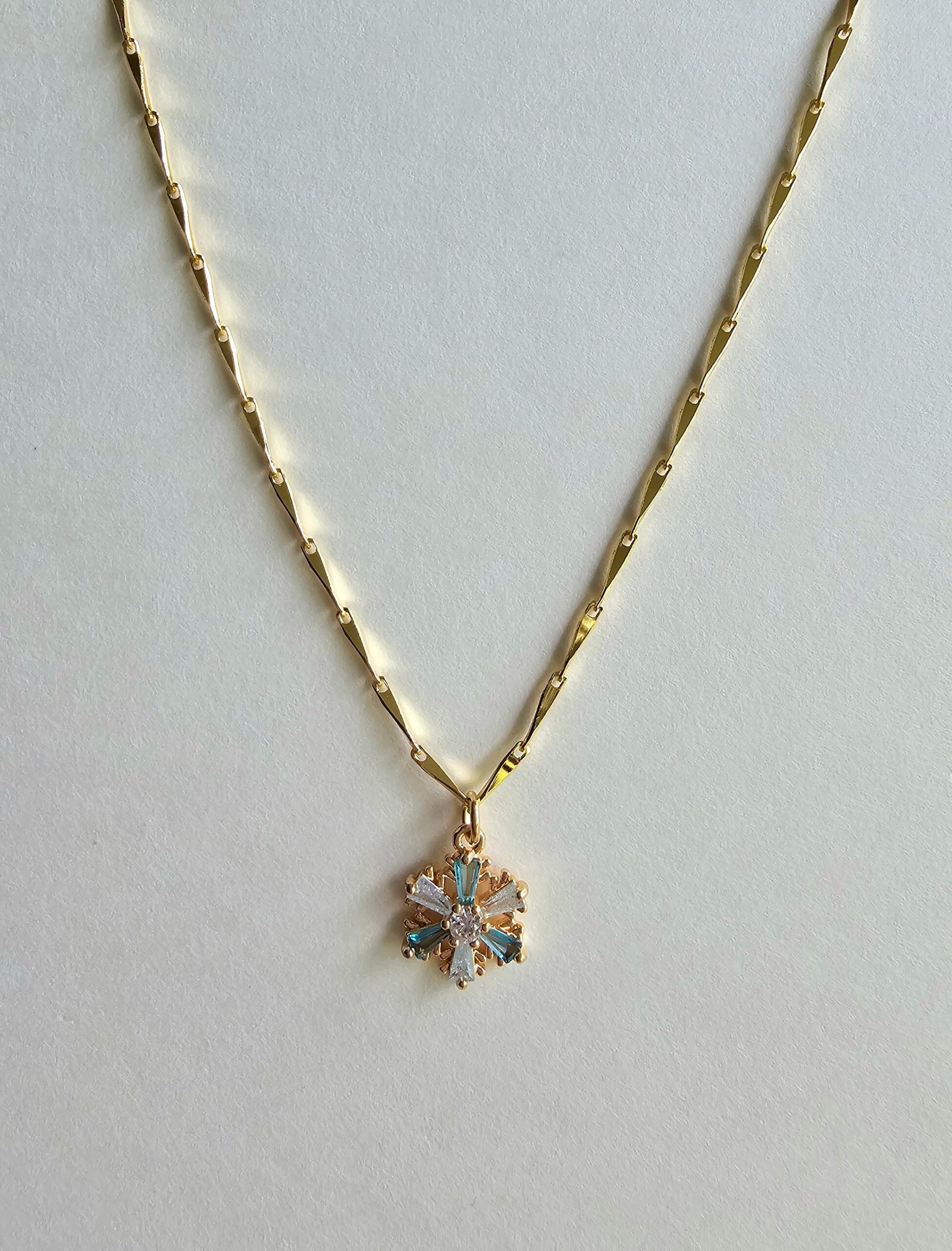 Gold plated 925 silver necklace with a snowflake-shaped crystal pendant featuring blue and clear stones on a delicate chain