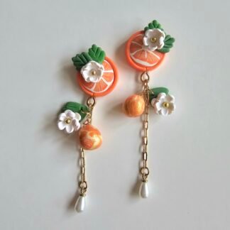 Handcrafted polymer clay citrus drop earrings with floral details, gold accents, and pearl drop by Haeng Bok Clay.