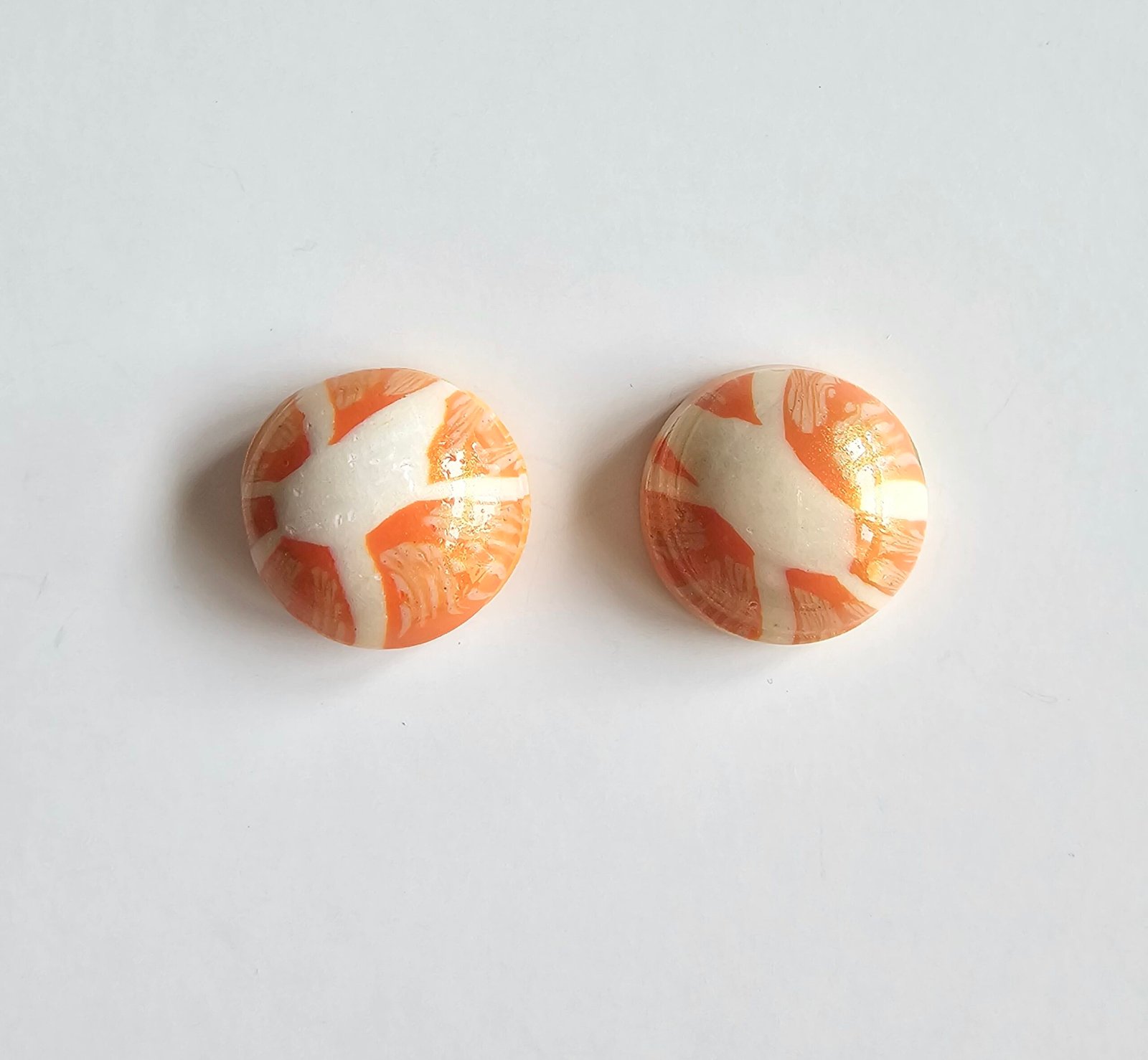 Handmade polymer clay citrus stud earrings in marbled orange and cream
