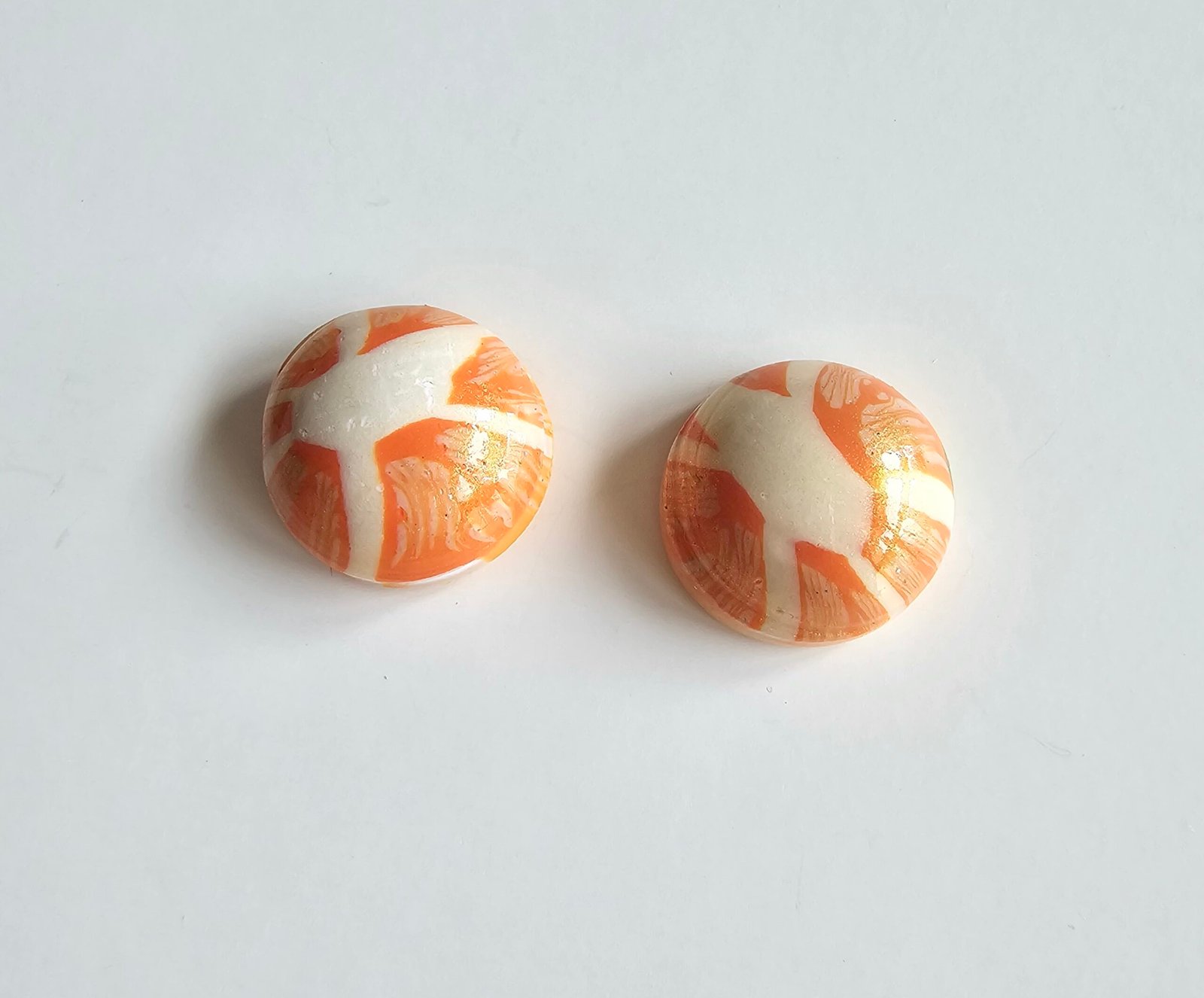 Handmade polymer clay citrus stud earrings in marbled orange and cream