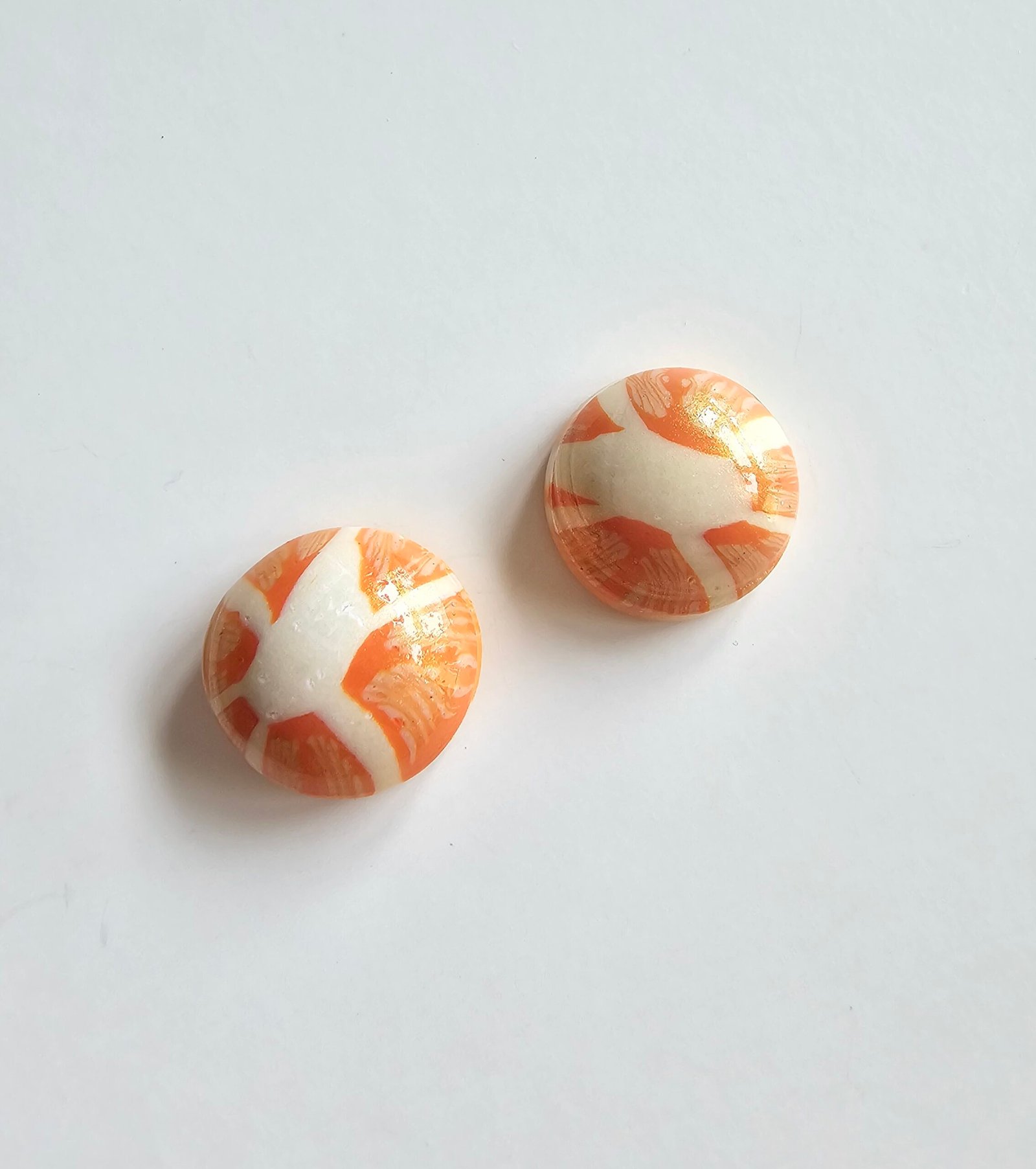 Handmade polymer clay citrus stud earrings in marbled orange and cream
