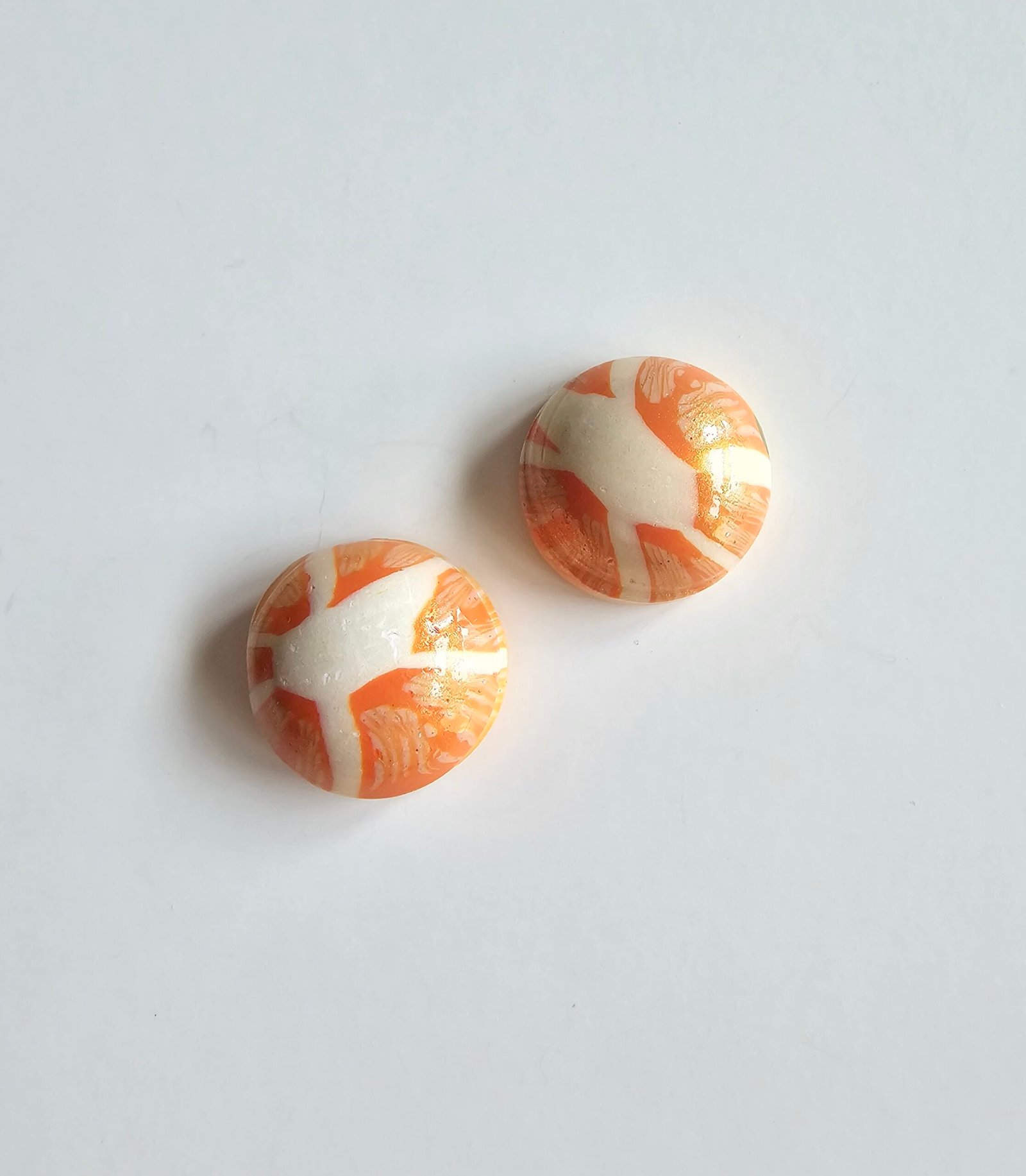 Handmade polymer clay citrus stud earrings in marbled orange and cream